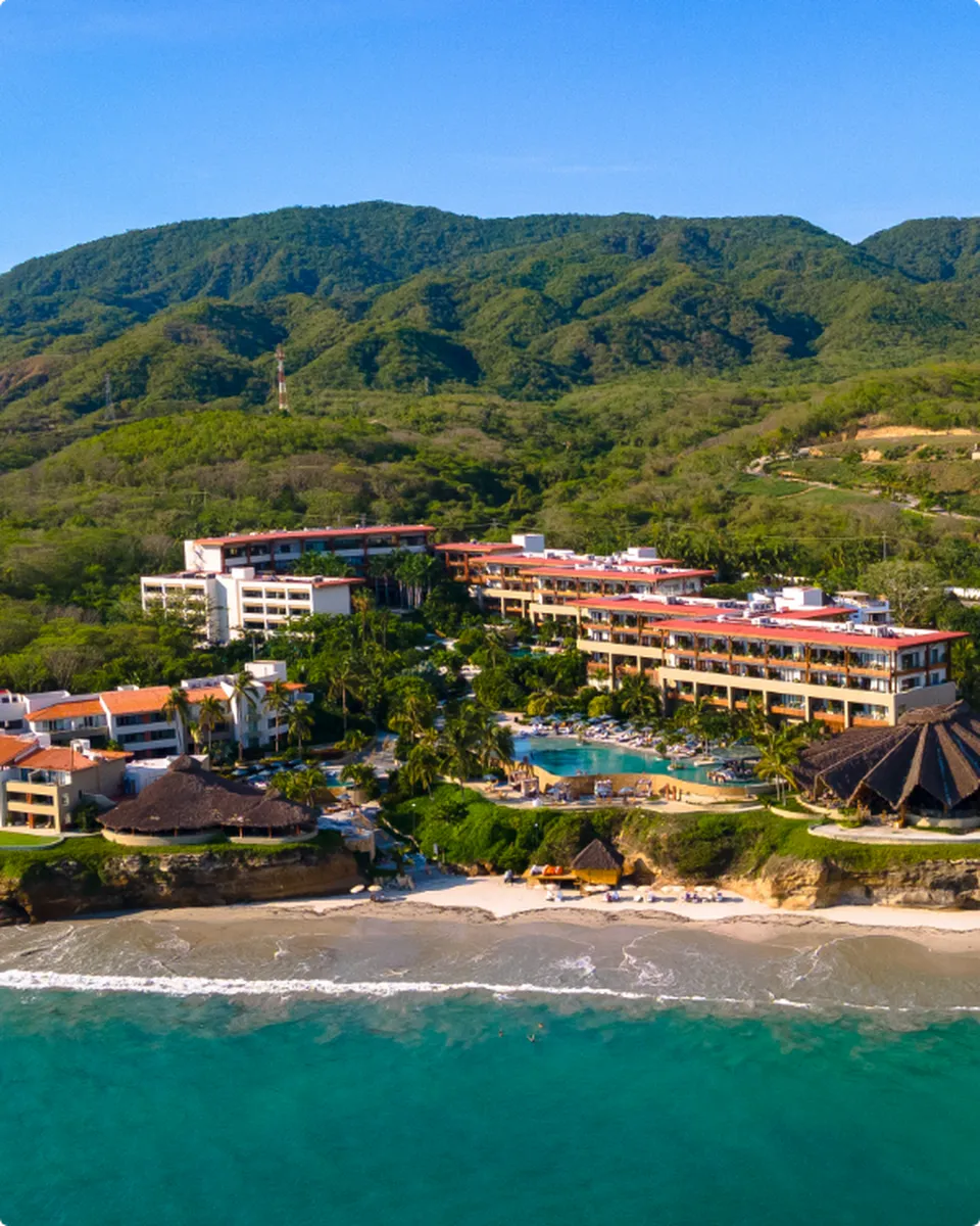 Vista aérea del resort Marival Armony Luxury Resort & Suites en Punta de Mita, mostrando la piscina infinita y el océano Pacífico al fondo.